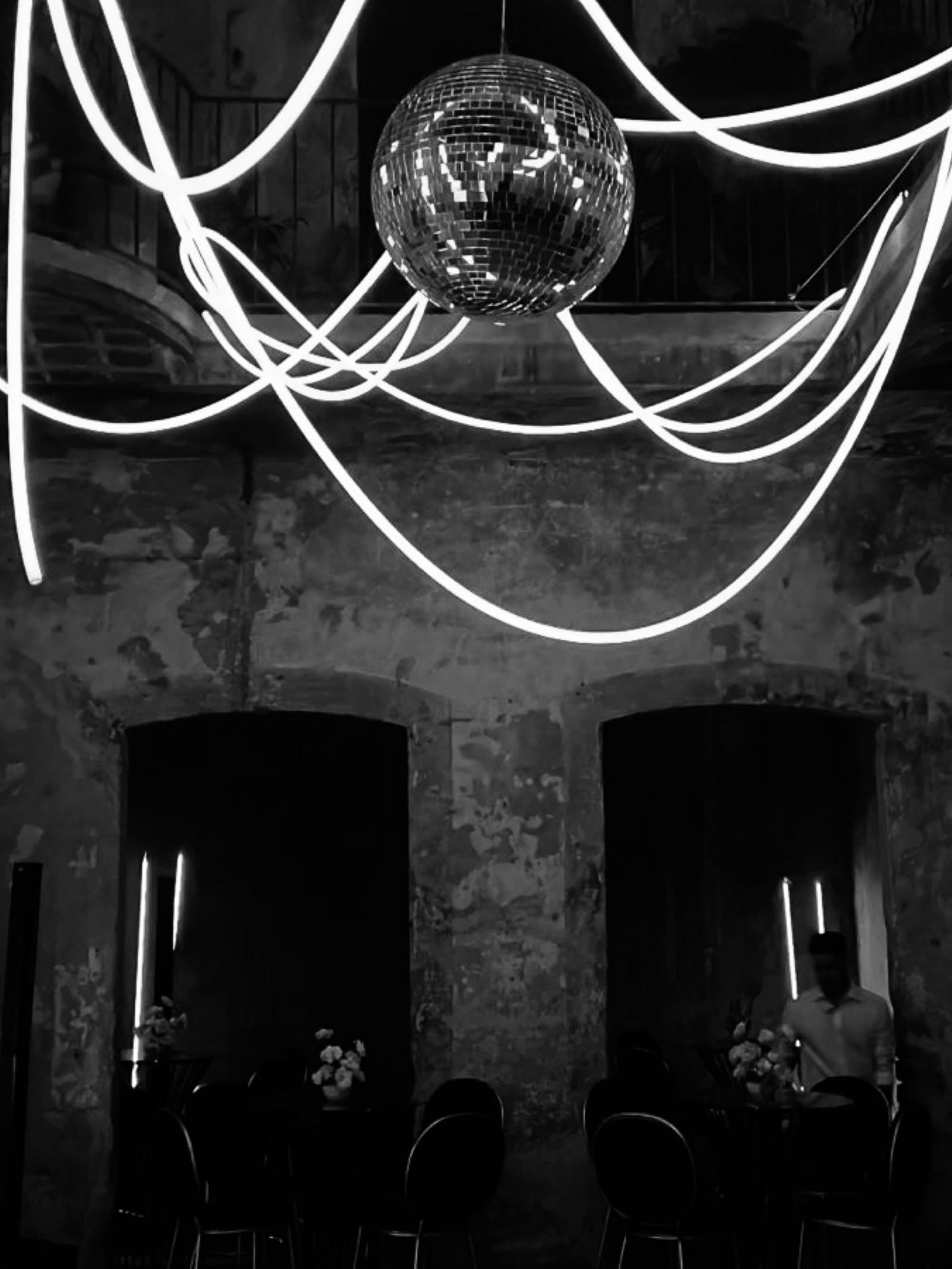 Neon installation and disco ball hung by vbmusic in a stone venue