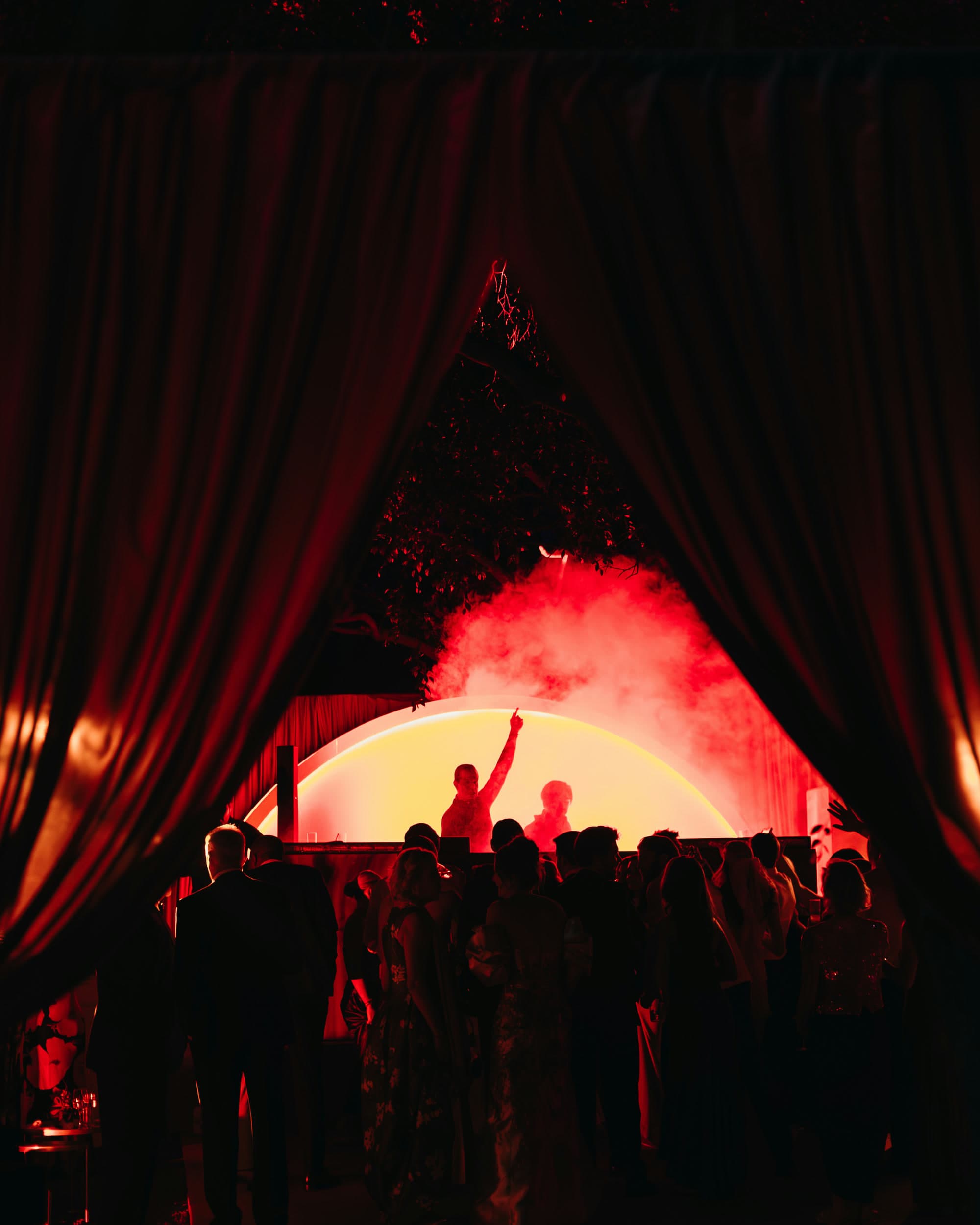 DJ set de vbmusic tras cortinas rojas en una boda de carpa
