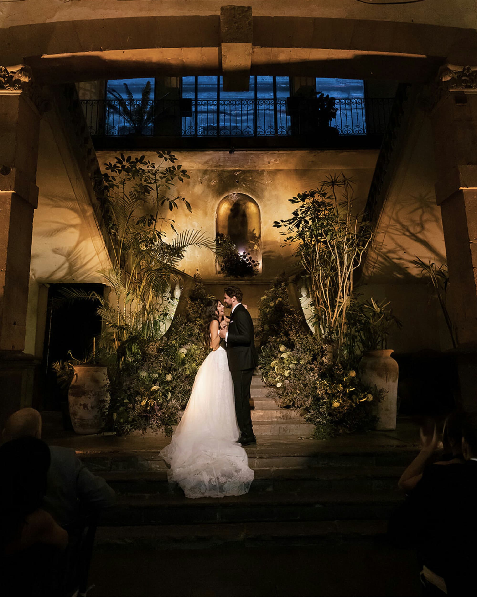 Bride and groom at a hacienda courtyard lit by vbmusic